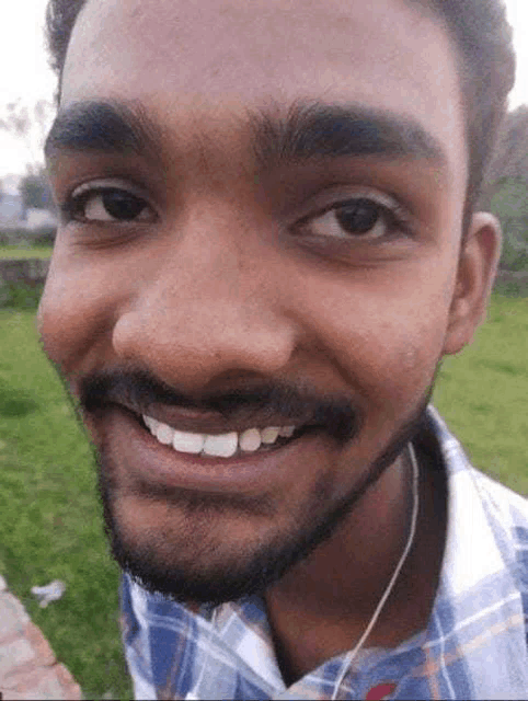 a close up of a man 's face with a beard and headphones smiling .