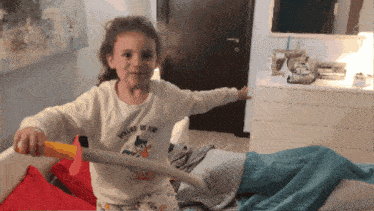 a little girl is holding a toy sword that says young of fun