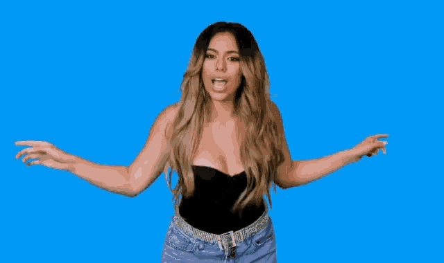 a woman in a black top and purple shorts is dancing with her arms in the air .
