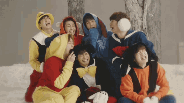 a group of young men wearing winnie the pooh costumes sit in the snow