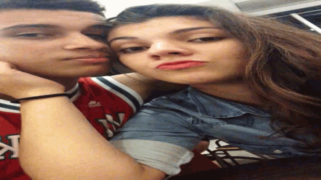 a man and a woman are posing for a picture and the man is wearing a jersey that says ny on it