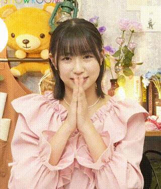 a girl in a pink dress with her hands folded in front of a teddy bear .