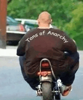a man is riding a motorcycle with a shirt that says tons of anarchy on it .