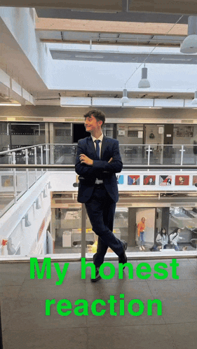a man in a suit and tie is standing on a balcony with his arms crossed and the words " my honest reaction " above him