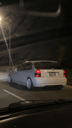 a white honda civic with a license plate that says kmc983