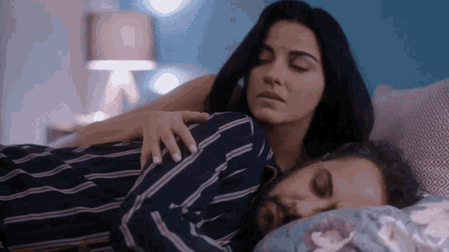 a woman is laying on a man 's chest while he sleeps