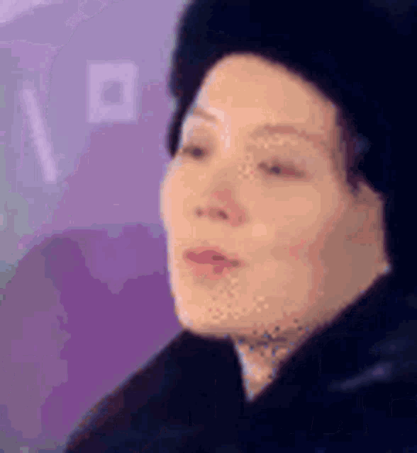 a close up of a woman wearing a black hat and a black jacket .