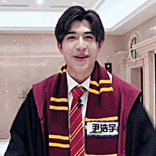 a man wearing a scarf and a name tag that says ' e ' on it