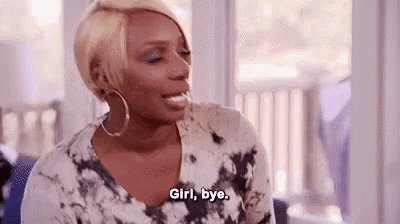a woman in a tie dye shirt is sitting in front of a window and saying `` girl , bye . ''