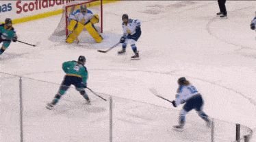 a hockey game is being played in front of a scotiabank advertisement