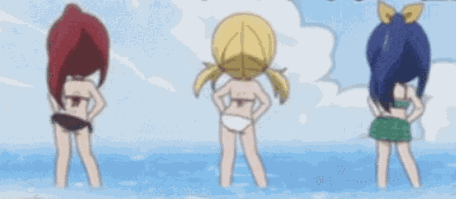 three girls in bikinis are standing in the water .
