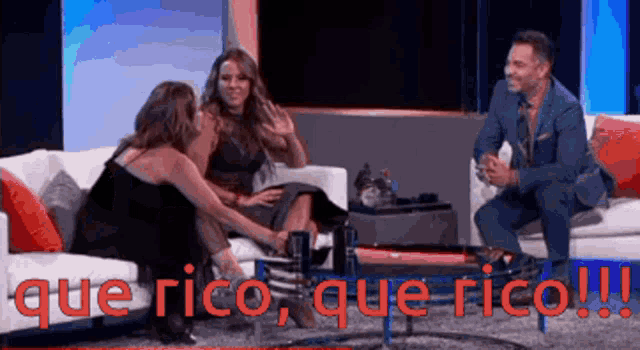 a man and two women are sitting on a couch with the words que rico que rico written on the screen