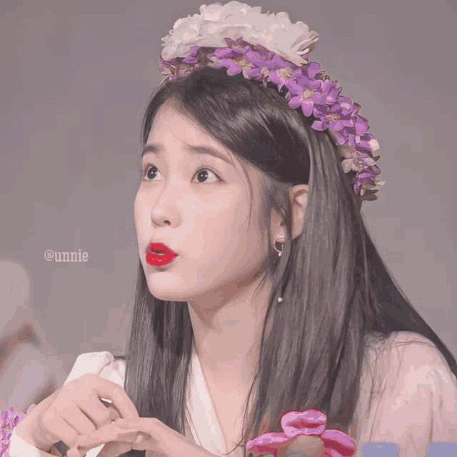 a close up of a woman wearing a headband with purple and white flowers