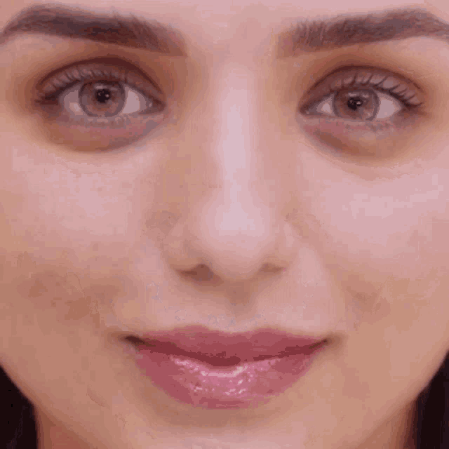 a close up of a woman 's face with a smile on it