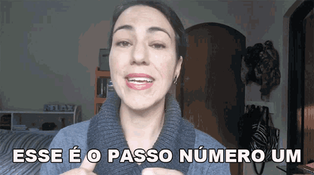 a woman wearing a sweater with the words esse e o passo numero um above her