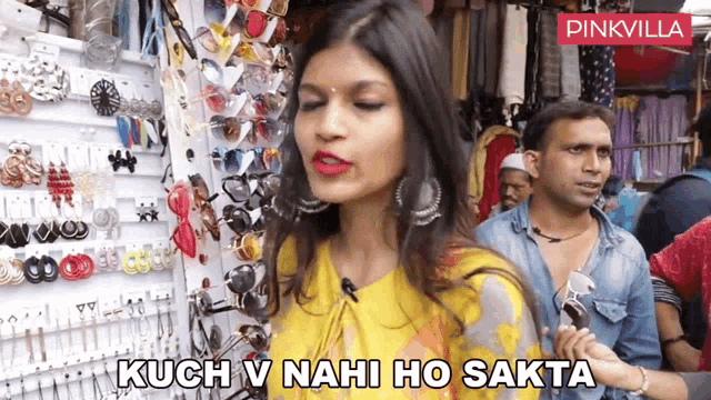 a woman stands in front of a display of sunglasses and earrings and says kuch v nahi ho sakta