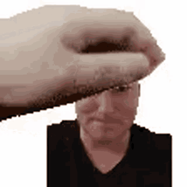 a hand is holding a man 's head in front of a man 's face .