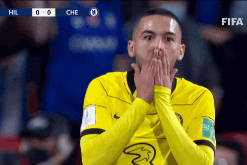 a soccer player covering his mouth with his hands during a match