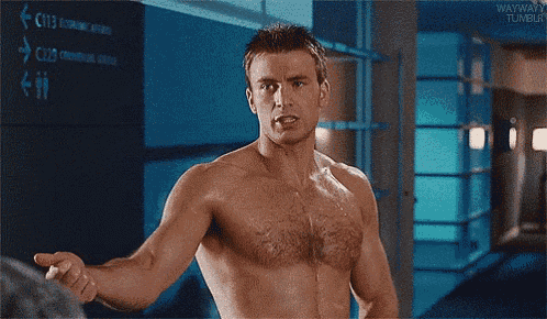 a shirtless man is standing in a hallway with his arms outstretched and pointing at something .