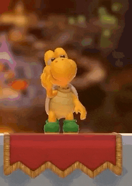a toy turtle is standing on top of a red table cloth .