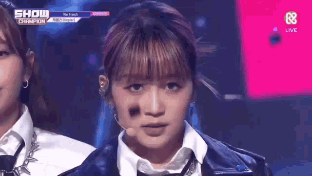 a close up of a woman 's face with a microphone in front of her .