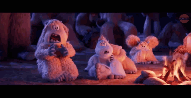 a group of stuffed animals are sitting around a campfire and one of them is screaming