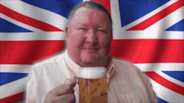 a man in front of a british flag holding a beer
