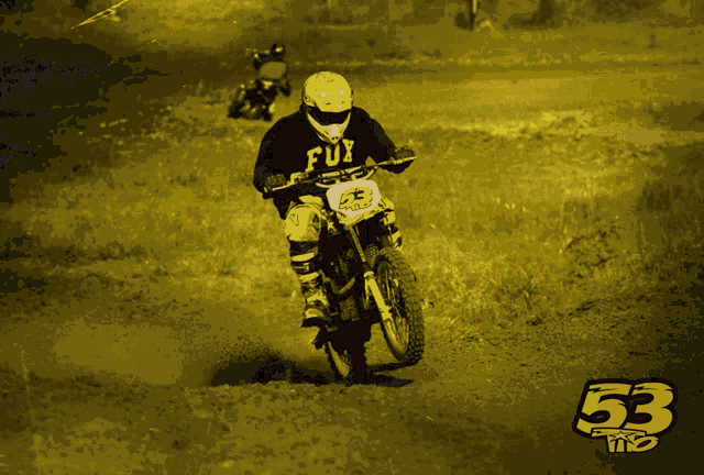 a person riding a dirt bike with the number 53