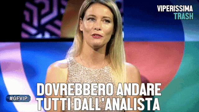 a woman stands in front of a sign that says " dovrebbero andare tutti dall ' analysta "