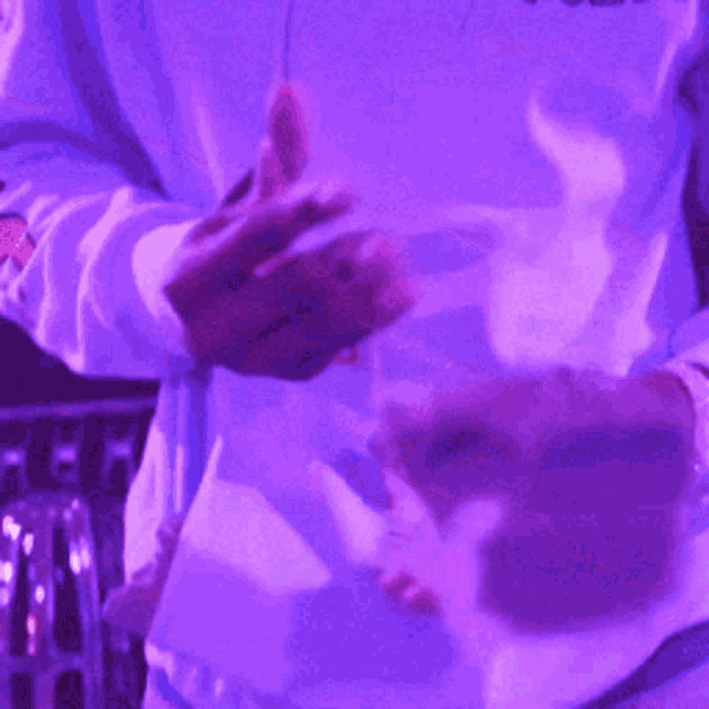 a man in a purple shirt is holding a purple object