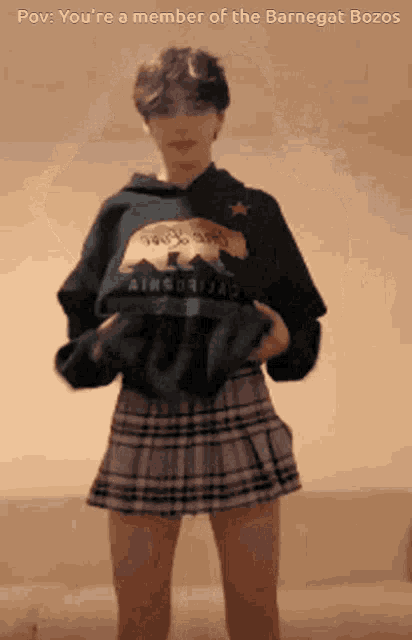 a person wearing a plaid skirt and a hoodie with the words " you 're a member of the barnegat bozos "