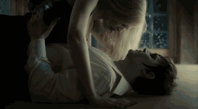 a woman is licking a man 's face with a tongue