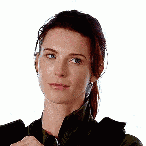 a close up of a woman 's face with a ponytail and a serious look on her face .