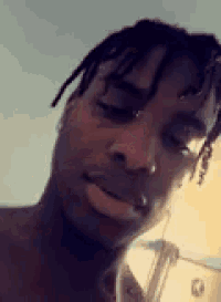 a close up of a man 's face with dreadlocks looking at the camera .