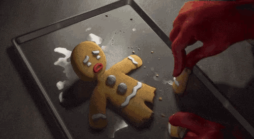 a gingerbread man is laying on a tray with icing on it