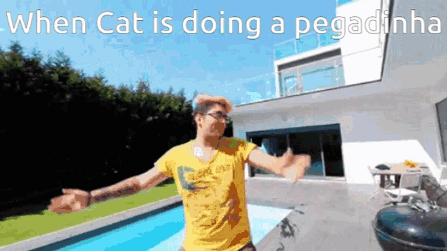 a man in a yellow shirt is standing next to a swimming pool with his arms outstretched ..