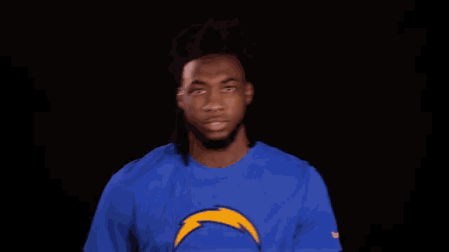 a man is wearing a blue shirt with a lightning bolt on it