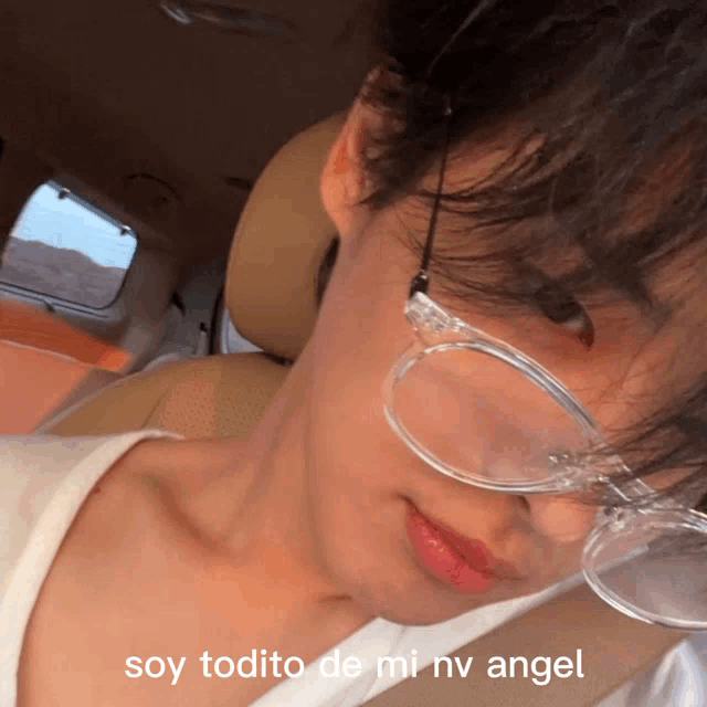 a close up of a person wearing glasses with the words soy todito de mi nv angel on the bottom