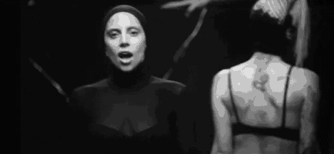 a black and white photo of a woman wearing a turtleneck and a mask .