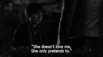 a black and white photo of a boy and a man with the caption " she doesn t love me she only pretends to "