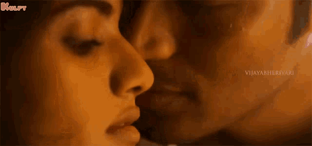 a man and a woman are kissing each other .