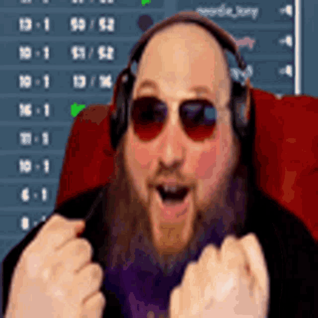 a man with a beard wearing headphones and sunglasses is sitting in a chair