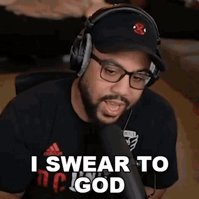 a man with a beard wearing headphones and glasses is talking into a microphone .