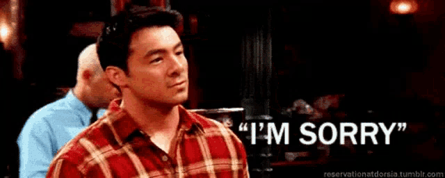a man in a red plaid shirt is saying i 'm sorry