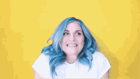 a woman with blue hair is making a funny face on a yellow background .