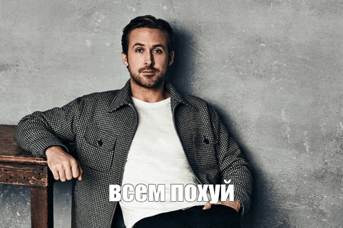 a man in a plaid jacket sits next to a wooden table with the words " всем похуй " written below him