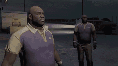 a man in a purple shirt with the letter t on it is standing next to another man