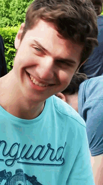 a young man wearing a blue shirt with the word guard written on it