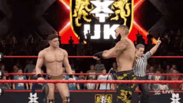 two wrestlers are in a ring with a sign that says jjk on it