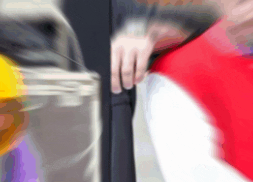 a blurry picture of a person 's hand holding a red and white object